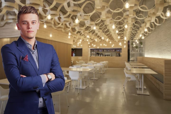 Um jovem de fato azul dentro de um restaurante
